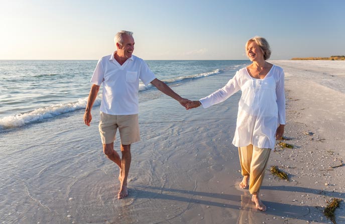 elderly-happy-couple-walk-beach